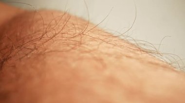Görünür saç folikülleri ve ince detaylarla insan derisinin dokusunu gösteren detaylı bir yakın çekim görüntüsü. Makro