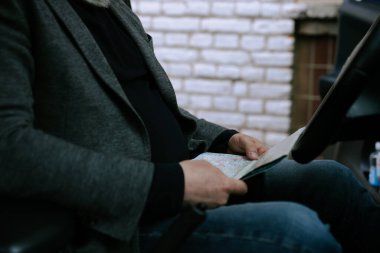 Arabadaki yaşlı bir adamın yol haritasına bakıp doğru yeri ya da yönü ararken çekilmiş bir fotoğrafı. Arabayla seyahat..