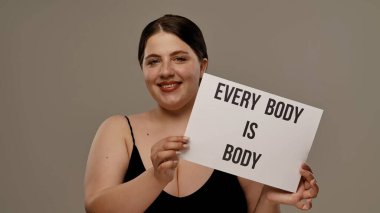 Bir kadın güçlü bir sig tutar. Vücut, vücudun pozitifliğini destekler, kendini sevmeyi ve kişisel yetkilendirmeyi destekler..