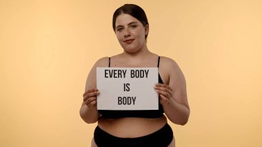 Bir kadın güçlü bir sig tutar. Vücut, vücudun pozitifliğini destekler, kendini sevmeyi ve kişisel yetkilendirmeyi destekler..