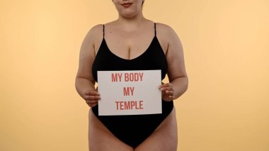 Bir kadın güçlü bir iç çekiş yapıyor Vücudum Tapınağım vücudum pozitifliği destekleyici bir ortamda kişisel gücü ve sevgiyi vurguluyor..