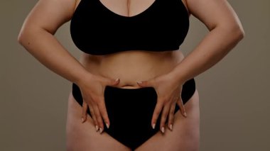 Görüntüde, göbeğinde kalp şekli oluşturan bir kadın var. Tarafsız bir arkaplana karşı aşkı ya da sağlık bilincini simgeliyor. Yavaş çekim