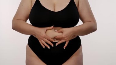 Kişilerin karnını gösteren, özfarkındalığı ve vücut kabulü temalarını vurgulayan bir manzara. Yavaş çekim