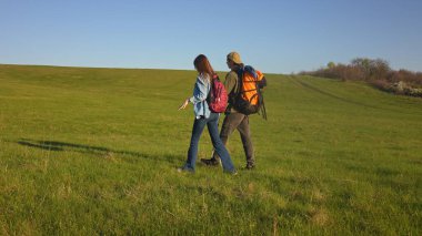 Berrak bir mavi gökyüzünün altında, huzurlu manzaranın ve temiz havanın tadını çıkaran bir çift..