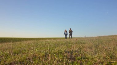 Berrak bir mavi gökyüzünün altında, huzurlu manzaranın ve temiz havanın tadını çıkaran bir çift..