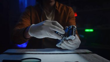 Bir insan, antika bir kamerayı dikkatlice tutar ve korumak için eldiven kullanır..