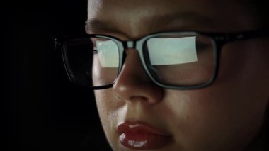 Kadın gözlükleriyle dijital bir belgeyi dikkatlice okuyor. Yaklaşın, ağır çekim.