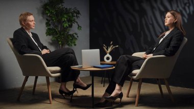 Modern bir ofis ortamında stratejileri tartışan iki profesyonel ciddi bir iş görüşmesi yapıyorlar..