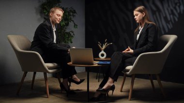 Modern bir ofis ortamında stratejileri tartışan iki profesyonel ciddi bir iş görüşmesi yapıyorlar..