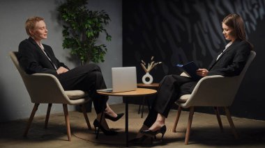 Modern bir ofis ortamında stratejileri tartışan iki profesyonel ciddi bir iş görüşmesi yapıyorlar..