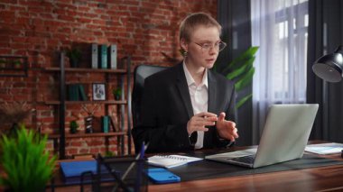 Kendini işine adamış bir birey, modern ofis ortamında bir masaya notlar yazarken görülüyor. Konsantrasyon ve verimliliği vurguluyor..