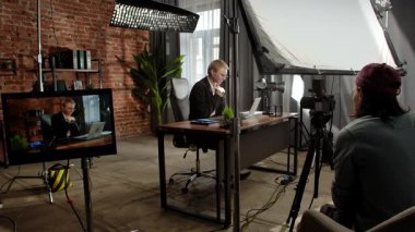 Sahne arkasında. Odaklanmış bir iş kadını masasında strateji düşünüyor. Ofis modern, dizüstü bilgisayarı ve düzgün düzenlenmiş belgeleri var..