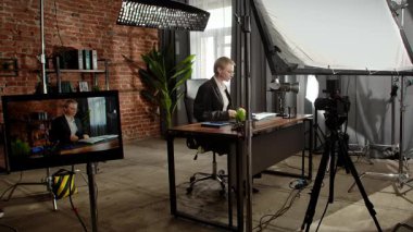 Sahne arkasında. Odaklanmış bir iş kadını masasında strateji düşünüyor. Ofis modern, dizüstü bilgisayarı ve düzgün düzenlenmiş belgeleri var..