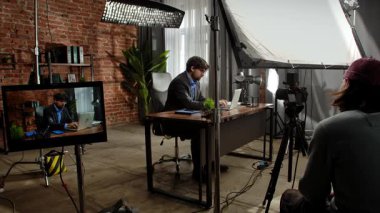 Sahne arkasında. Takım elbiseli bir işadamı, modern ofis ortamında tuğla duvarlar ve dekorlarla dizüstü bilgisayarına odaklanmıştı..