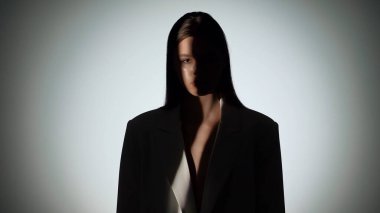 Çarpıcı bir portre dramatik ışıklandırmayla bir yüzünü gölgede bırakan bir kadın, gizemli bir etki yaratıyor..