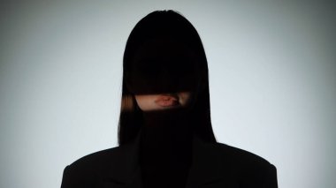 Çarpıcı bir portre dramatik ışıklandırmayla bir yüzünü gölgede bırakan bir kadın, gizemli bir etki yaratıyor..