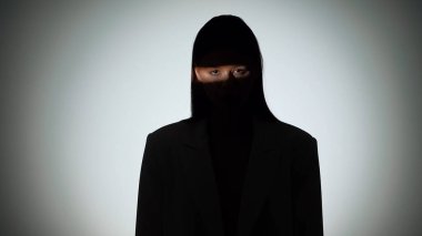 Çarpıcı bir portre dramatik ışıklandırmayla bir yüzünü gölgede bırakan bir kadın, gizemli bir etki yaratıyor..