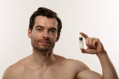 Bir erkek, deri dokusunu geliştirmek ve beslenmek için deri serumunu nazikçe kullanır..