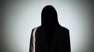 Çarpıcı bir portre dramatik ışıklandırmayla bir yüzünü gölgede bırakan bir kadın, gizemli bir etki yaratıyor..