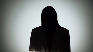 Çarpıcı bir portre dramatik ışıklandırmayla bir yüzünü gölgede bırakan bir kadın, gizemli bir etki yaratıyor..