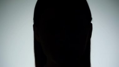 Bir kadının yüzünü gösteren çarpıcı bir portre. Işık huzmesi ve gölgeyle bölünmüş, dramatik ve gizemli bir etki yaratıyor..