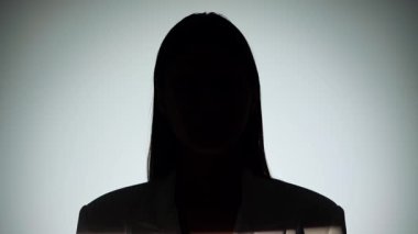 Çarpıcı bir portre dramatik ışıklandırmayla bir yüzünü gölgede bırakan bir kadın, gizemli bir etki yaratıyor..