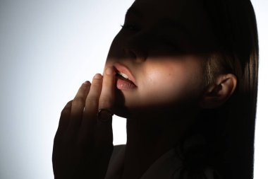 Altın yüzüklü bir kadının elini gösteren bir portre, ışık ve gölge oyunlarını vurguluyor..