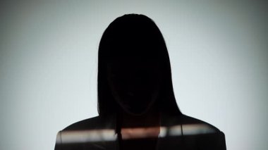 Çarpıcı bir portre dramatik ışıklandırmayla bir yüzünü gölgede bırakan bir kadın, gizemli bir etki yaratıyor..