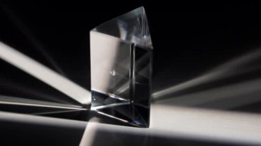 Açık bir prizma büyüleyici ışık ve gölge desenleri oluşturarak büyüleyici bir optik etki yaratıyor. Macro, ağır çekim.