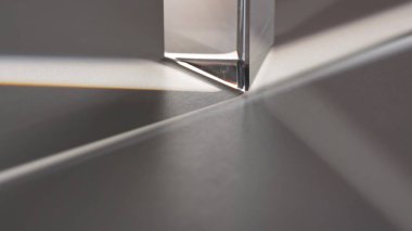 Bir prizma yüzeyde büyüleyici ışık ve gölge desenleri yaratarak soyut ve modern estetik özellikler sergiliyor. Makro