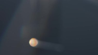 Işığı yansıtan ve kıran, soyut desenler ve ince renk değişimleri yaratan bir prizmanın görüntüsü. Macro, ağır çekim.