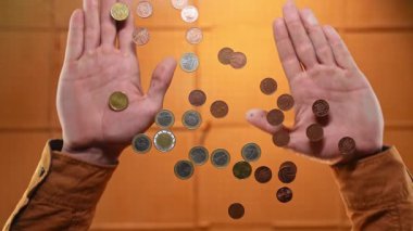 Birikimleri sembolize eden, sıcak bir arka plana karşı üçlü bir düzende çeşitli avro sikkelerini gösteren iki el. Yavaş çekim