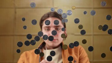 Madeni paralar yansıtıcı bir yüzeye doğru düşüyor gibi görünüyor, bir insanın altında görüldüğü gibi eşsiz bir görsel bakış açısı sağlıyor. Yavaş çekim