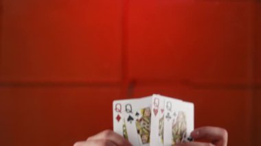 Canlı kırmızı bir arkaplana karşı hayranların düzenlediği dört oyun kartından oluşan bir set. Yavaş çekim
