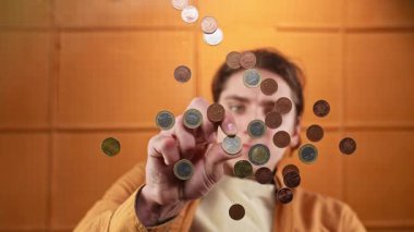 Bir insan yüzen sikkelere dokunmak için uzanır, ilgi çekici bir hareket ve merak gösterisi sergiler. Yavaş çekim