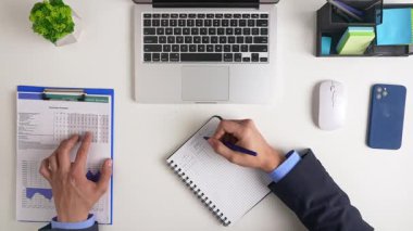 İyi organize edilmiş bir çalışma alanı, açık bir dizüstü bilgisayar, defter ve ofis malzemeleri, iş için ideal. Üst çekim