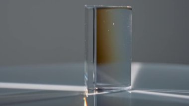 Cam prizma aydınlanır ve karanlık bir arkaplanda ışık tayfı oluşturur. Kırılma, canlı renkler yaratır. Macro, ağır çekim.