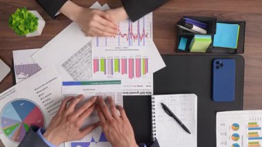 Profesyoneller büyüme stratejilerini tartışmak ve ekonomik performansı analiz etmek için işbirliği içinde mali tablolar ve verileri gözden geçirirler. Üst çekim