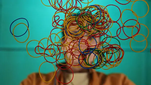 Renkli lastiklerden oluşan soyut bir düzenleme. Parlak yeşil bir zemin üzerinde gelişigüzel yüzüyorlar..