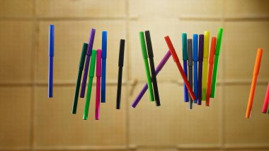 Havada yüzen renkli işaretlerden oluşan bir koleksiyon, basit bir karton zemin karşısında, canlı ama minimalist bir kompozisyon yaratıyor..