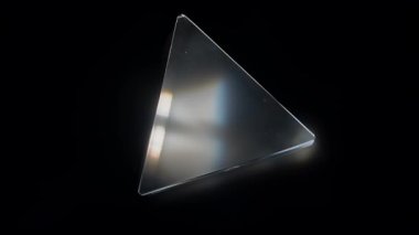 Bir cam prizma ışığı renk spektrumuna dağıtır, ışığın kırılmasını ve ayrılmasını resmeder. Macro, ağır çekim.