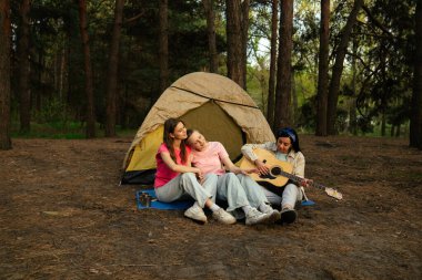 Üç arkadaş ormanda bir çadırda oturur, müziğin ve doğal çevrenin tadını çıkarır, anılar yaratırlar..