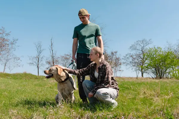 Genç bir çift güneşli bir günü köpekleriyle parkta geçiriyor. Doğanın ve arkadaşlığın tadını çıkarıyorlar..