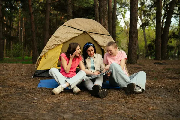 Üç arkadaş ormanda kamp yaparken heyecan verici bir an yaşadılar, bir çadırın etrafında toplandılar..