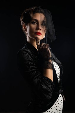 Siyah peçeli ve kırmızı rujlu zarif bir kadının portresi klasik bir güzellik taşıyor..