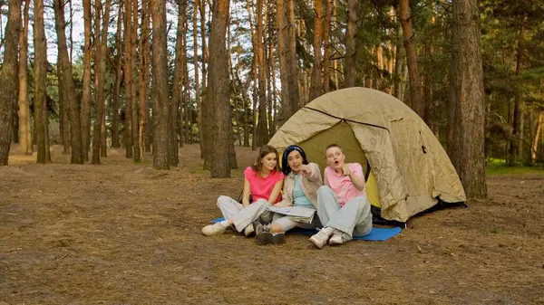 Üç arkadaş ormanda kamp yaparken heyecan verici bir an yaşadılar, bir çadırın etrafında toplandılar..