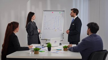 İş dünyasından profesyonellerden oluşan bir ekip, bir çalışma ortamında verileri analiz etmek ve stratejileri tartışmak üzere bir tablonun etrafında toplandı..