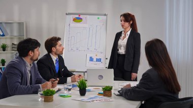 İş dünyasından profesyonellerden oluşan bir ekip, bir çalışma ortamında verileri analiz etmek ve stratejileri tartışmak üzere bir tablonun etrafında toplandı..