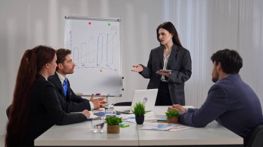 Bir iş toplantısı sırasında bir takımın alkış tutması, başarı ve işbirliğini sembolize ediyor..