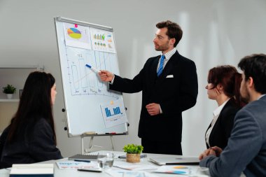 İş dünyasından profesyonellerden oluşan bir ekip, bir çalışma ortamında verileri analiz etmek ve stratejileri tartışmak üzere bir tablonun etrafında toplandı..